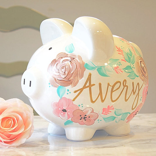 Custom painted piggy bank for girls, showcasing delicate flowers—ideal for saving baby's first coins